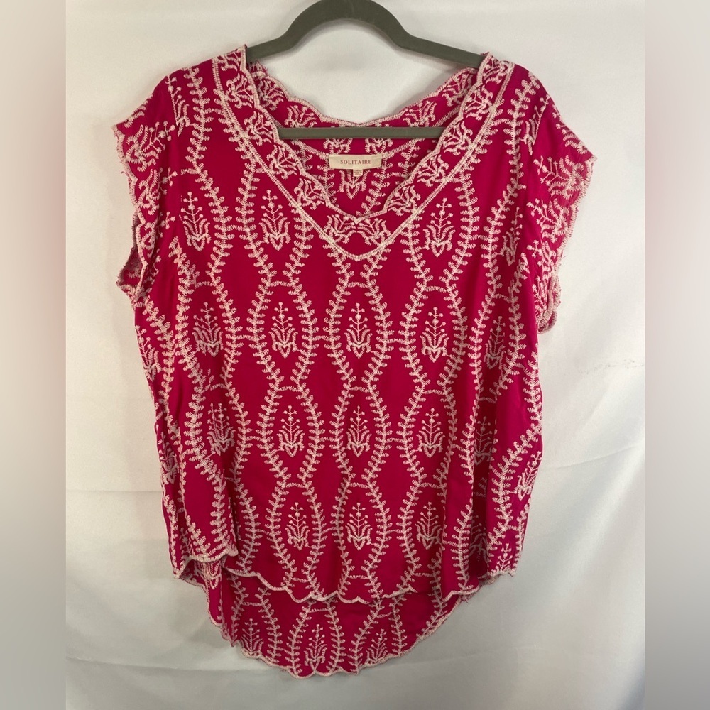 This is a hot pink blouse with loose sleeves and white embroidery. By Solitaire.
